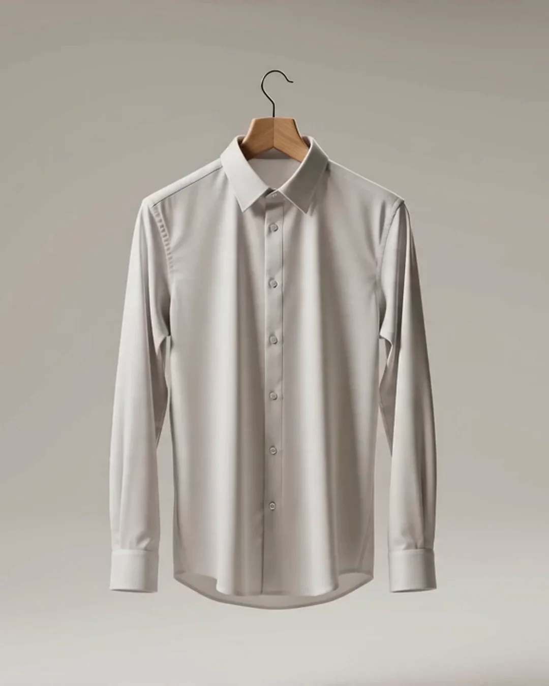 White button-down shirt on a wooden hanger in a studio